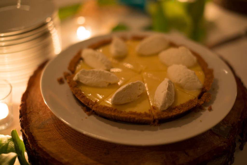 A key lime pie on a wooden board under candlelight, Tofino