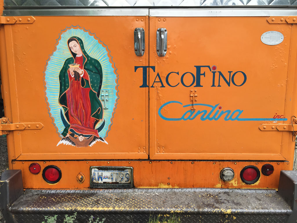 The orange Tacofino truck with its painted Guadalupe on the back doors, Tofino